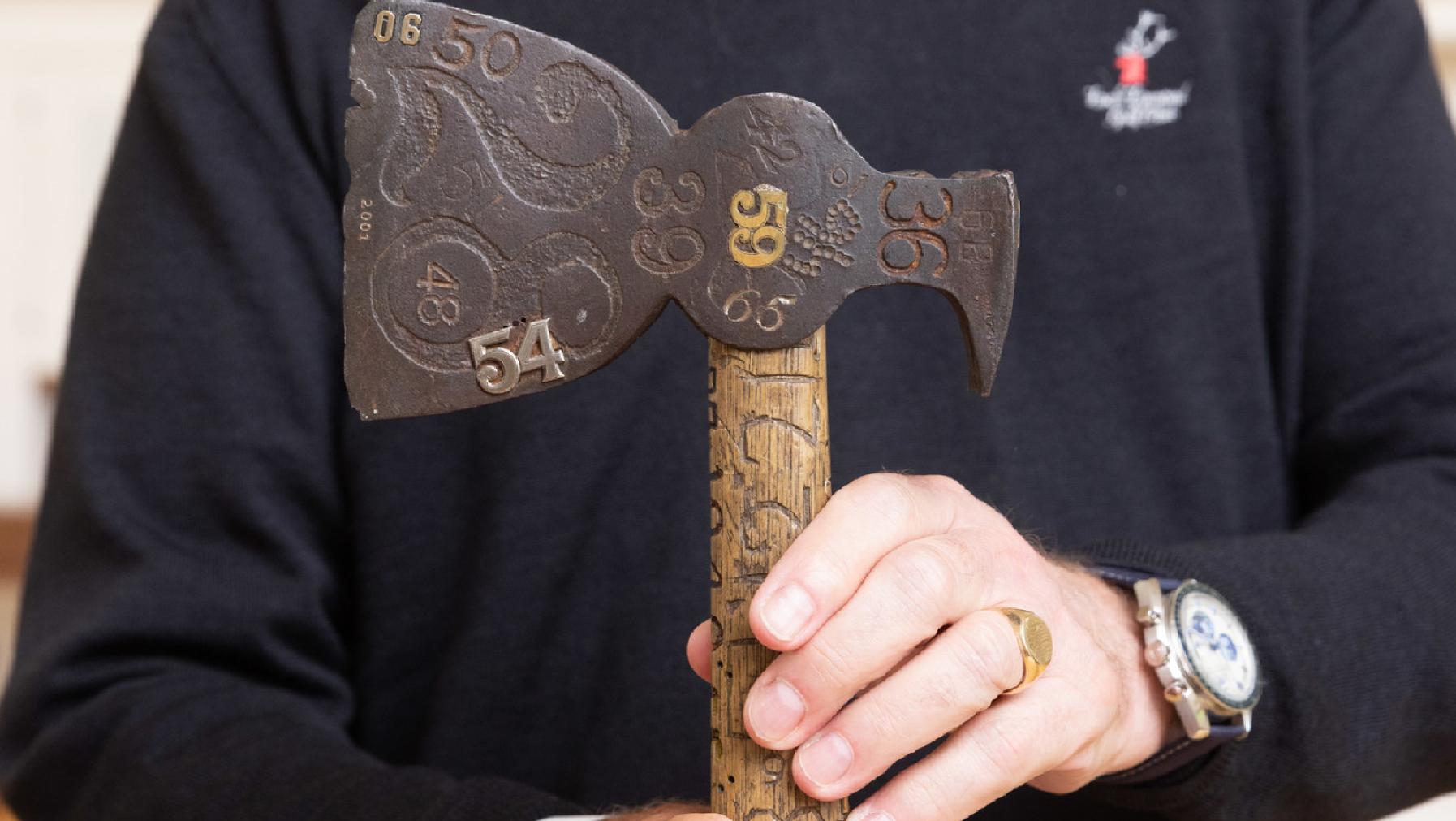 Close-up of the original hatchet with carvings and engravings of various class years from the early and mid-20th century.