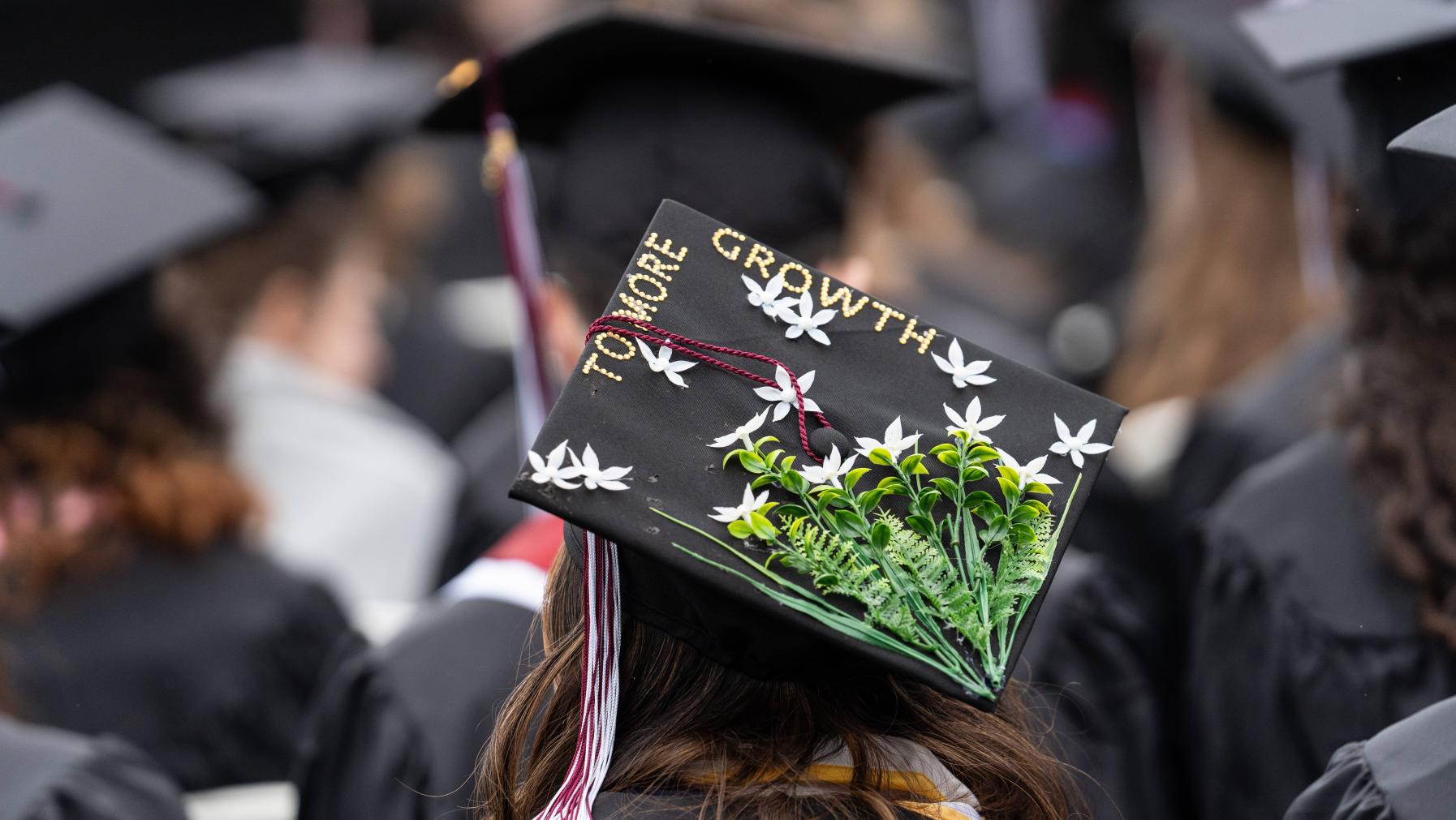 Decorated mortar board at Commencement 2024 with flowers and text that reads: To More Growth