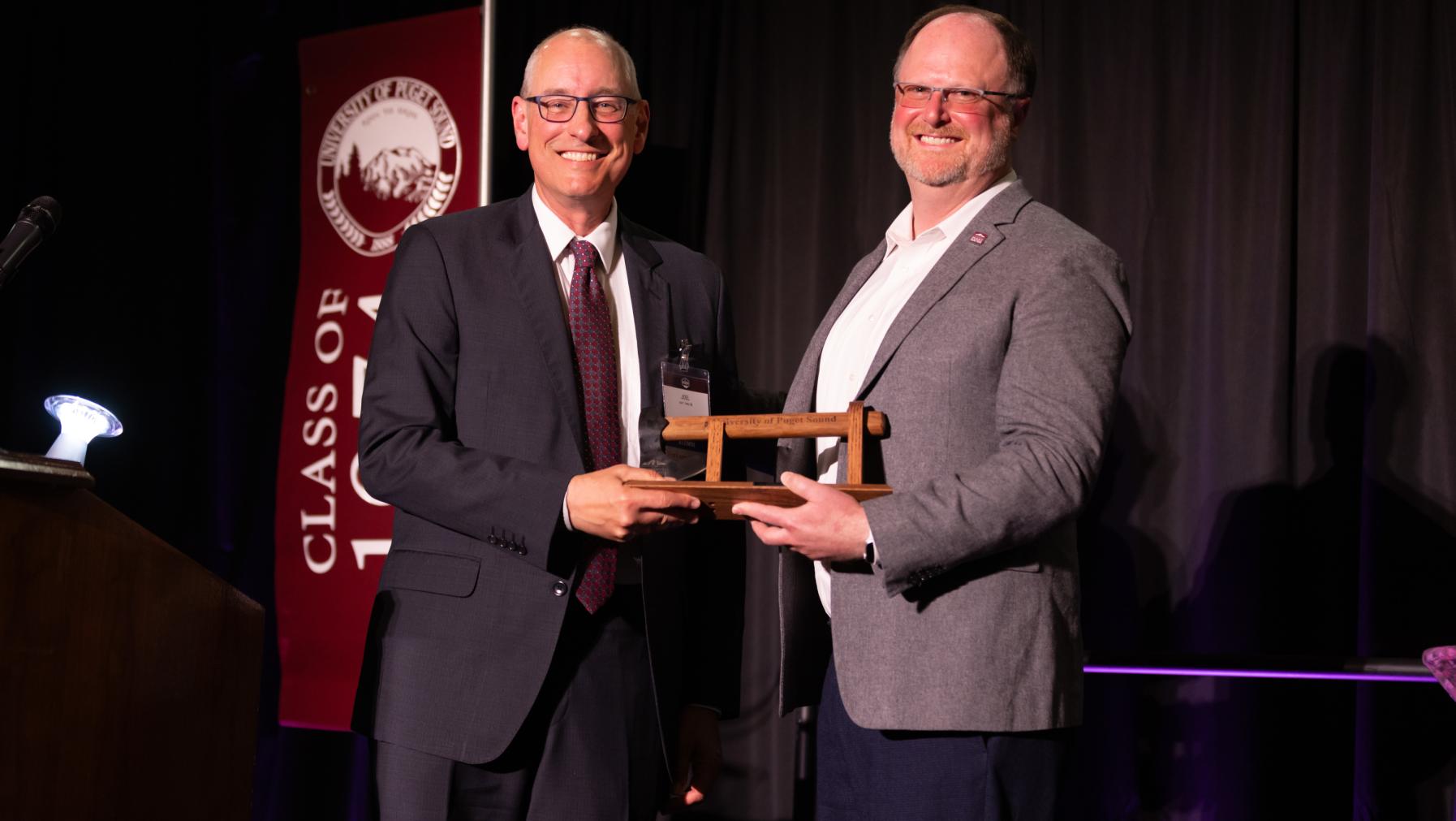 Outgoing Alumni Council Executive Committee President Ted Meriam '05 presents an the Distinguished Alumni Award for Service to Puget Sound to Joel Hefty '86.