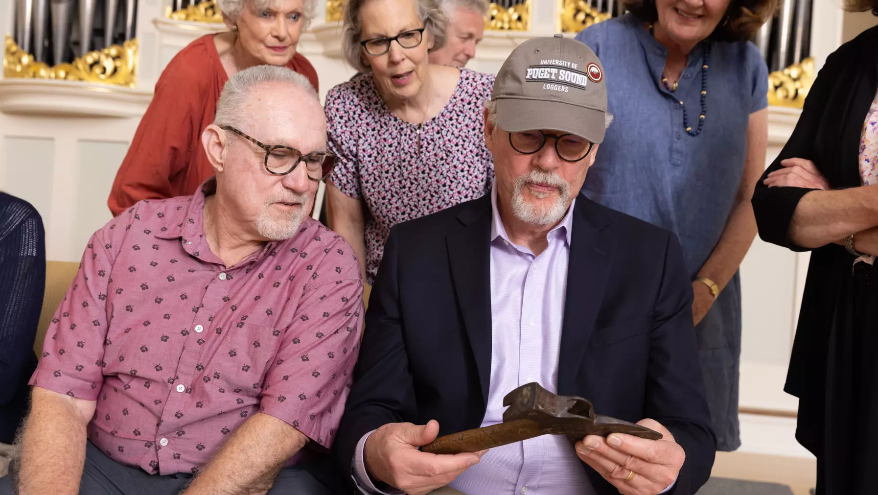 Golden Loggers celebrating their 50-year reunion check out the hatchet, under the watchful eyes of a Security Services officer.