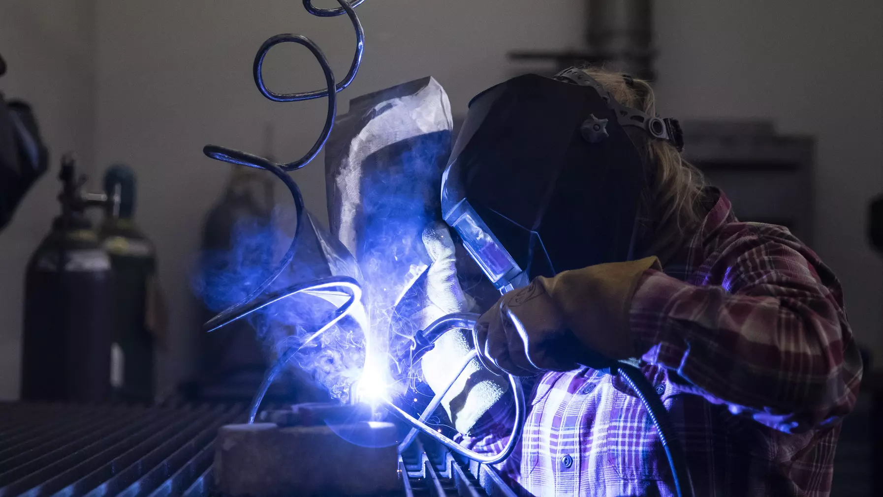 Student welding a sculpture