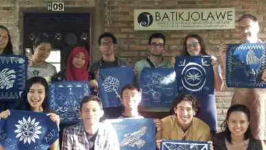 A group of people holding up Batik artwork