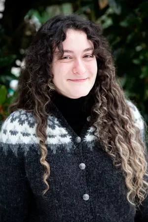 Headshot of woman standing in front of trees