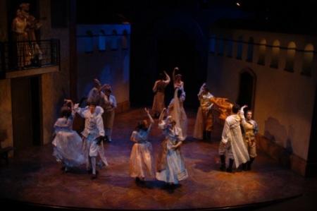 Actors dancing in a circle on stage