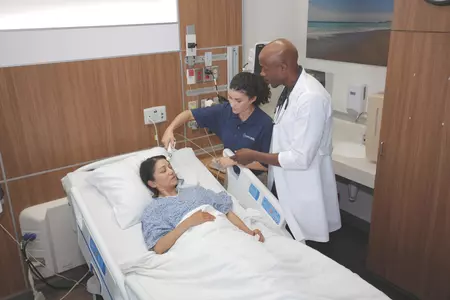 Medical personnel attending to a patient  in a hospital bed