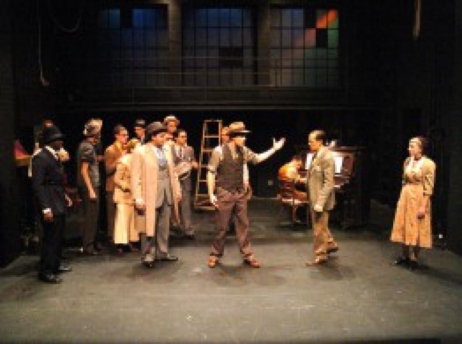 Actors in costume talking on stage in a half circle