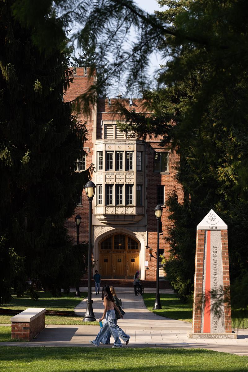 Two students walk in front of Collins Library